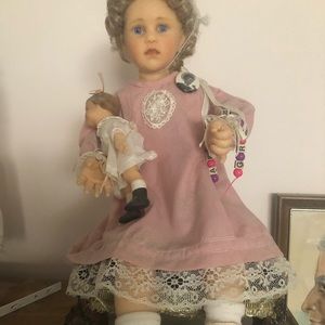Used like new porcelain doll with baby on velvet cushion mint condition